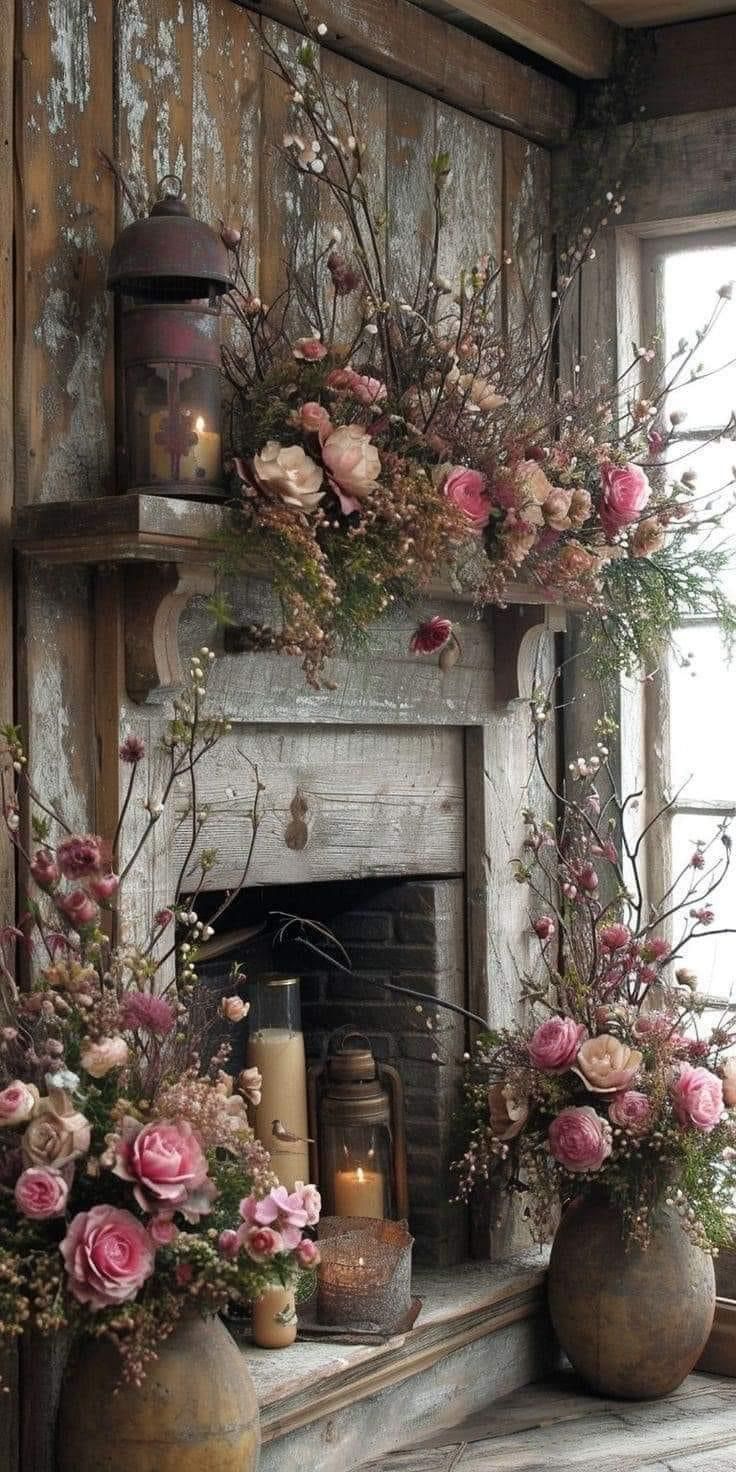 two vases filled with flowers sitting on top of a mantle next to a window