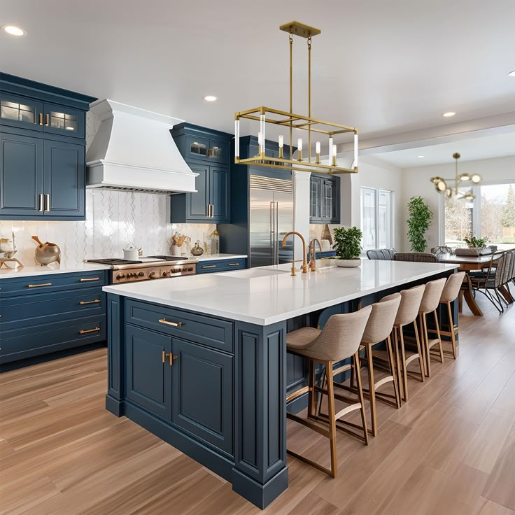 a large kitchen with blue cabinets and white counter tops, wooden flooring and an island in the middle