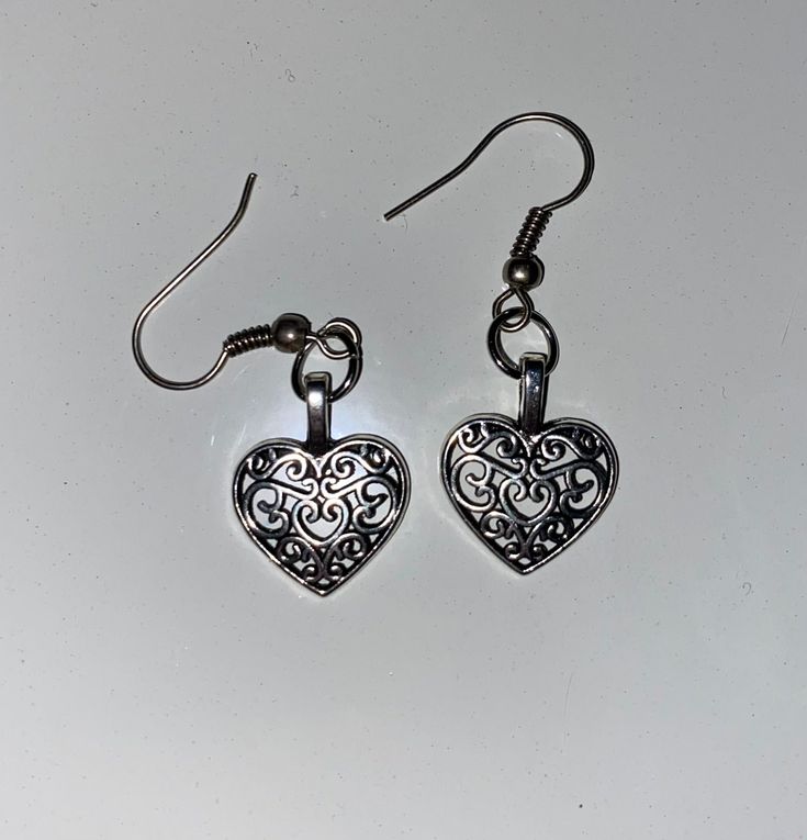 Heart dangle earrings with heart design in the middle. The backings are made of typical craft store metal earring wire so they should not turn your skin green and they should be hypoallergenic. These unique charms were thrifted so I am not sure of the type of metal its made with. The jewelry has been sanitized as well. Message me with any questions! Metal Dangle Heart Earrings With Heart Charm, Heart Charm Metal Earrings For Gift, Double Heart Metal Earrings For Gift, Metal Heart Earrings Gift, Nickel-free Metal Heart Earrings As Gift, Valentine's Day Metal Drop Earrings, Metal Heart Dangle Earrings For Gift, Vintage Heart Charm Drop Earrings, Metal Dangle Earrings For Valentine's Day