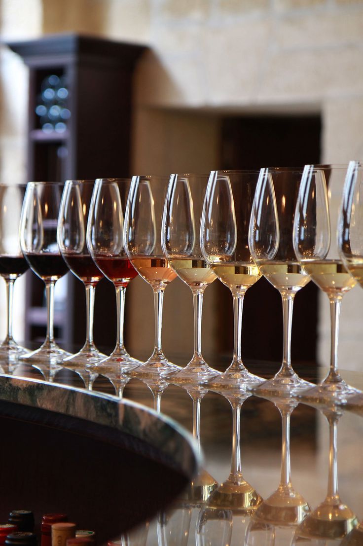 several glasses of wine are lined up on a bar