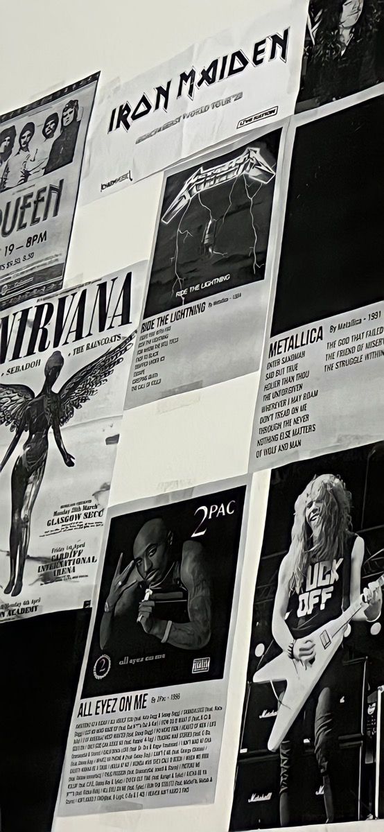 a wall covered with posters and pictures of rock bands in black and white, including an electric guitar