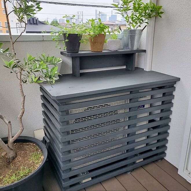 two potted plants are sitting on top of a stack of pallets in front of a window