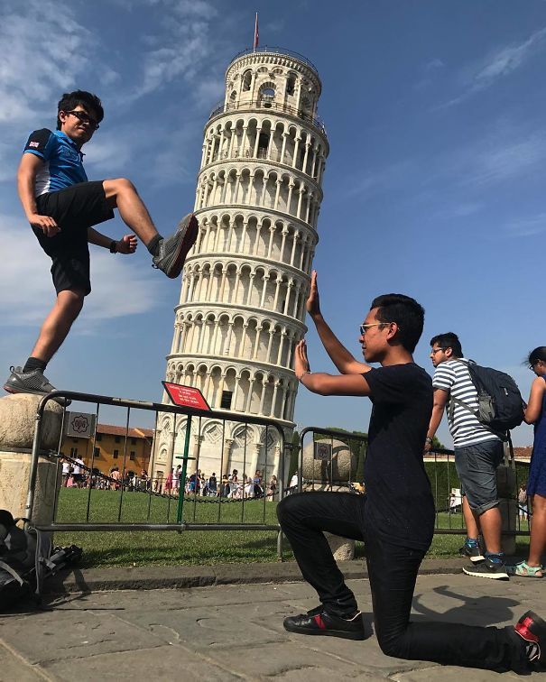 a man standing on top of a tall tower next to another man in front of a building