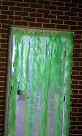 a green curtain hanging from the side of a brick wall in front of a door