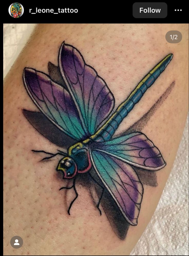 a colorful dragonfly tattoo on the thigh