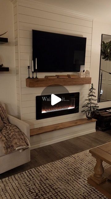 a living room with a couch, fireplace and television mounted on the wall above it