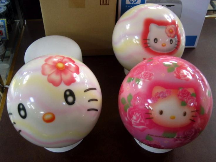 three hello kitty ball ornaments sitting on top of a table