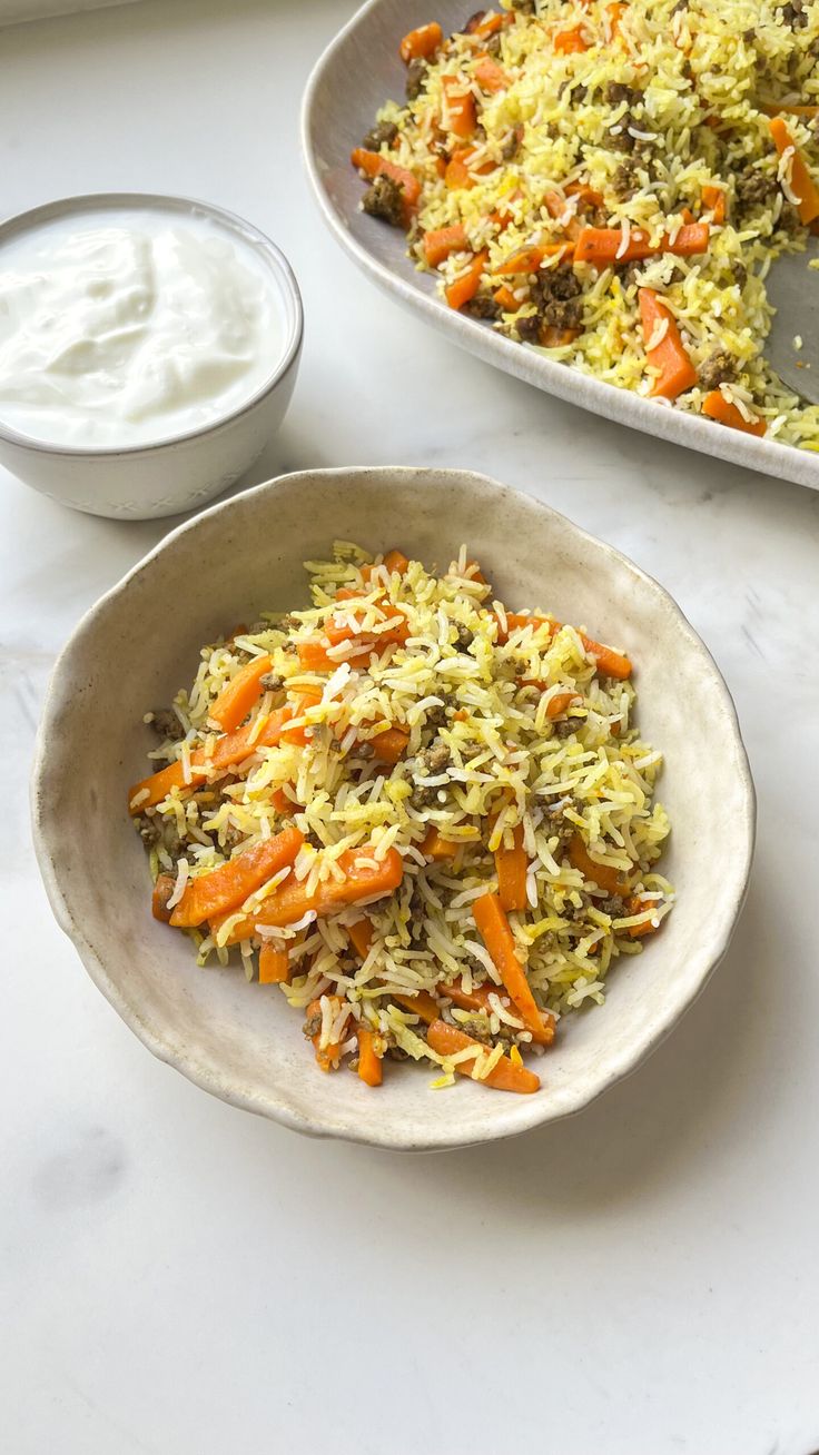 two bowls filled with rice and carrots next to a bowl of yogurt