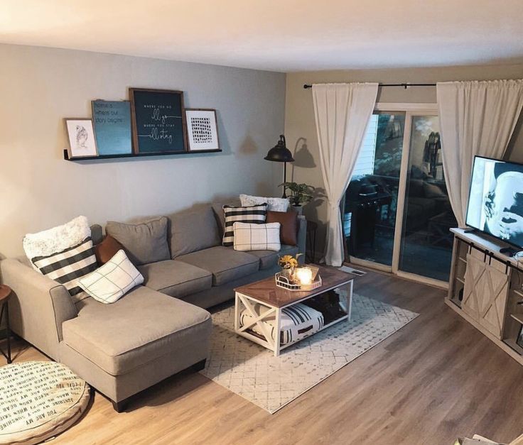 a living room filled with furniture and a flat screen tv sitting on top of a wooden floor