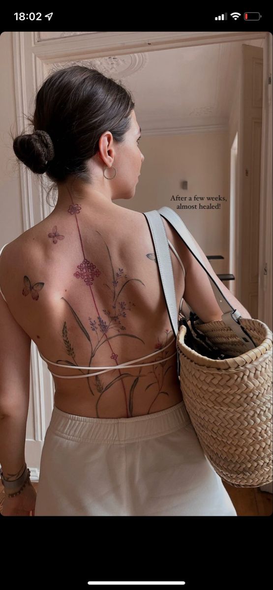 a woman with tattoos on her back holding a basket