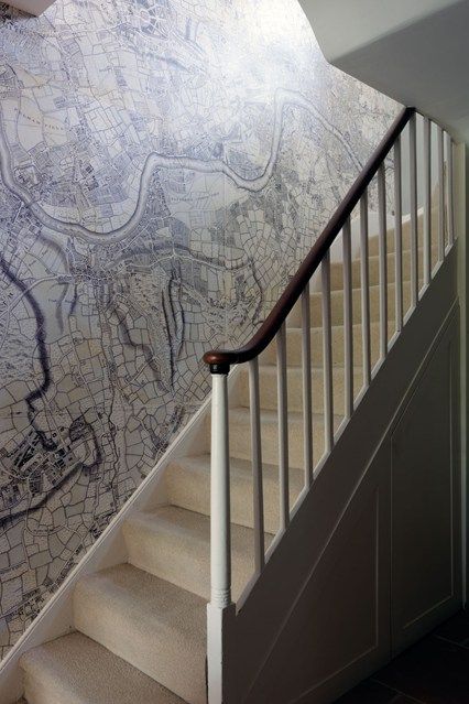 a stair case next to a wall with a map painted on it and another handrail