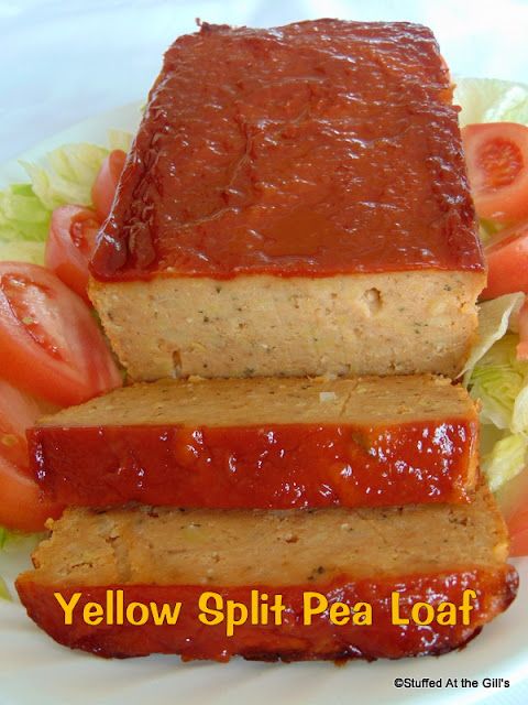 two slices of meatloaf on a plate with lettuce and tomatoes