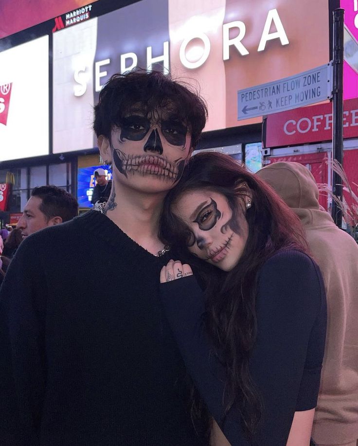 two people in skeleton makeup standing next to each other