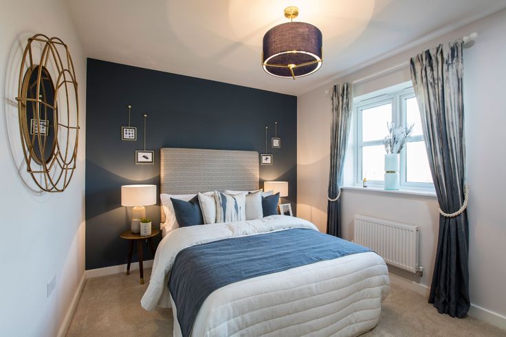 a bedroom with blue walls and white bedding