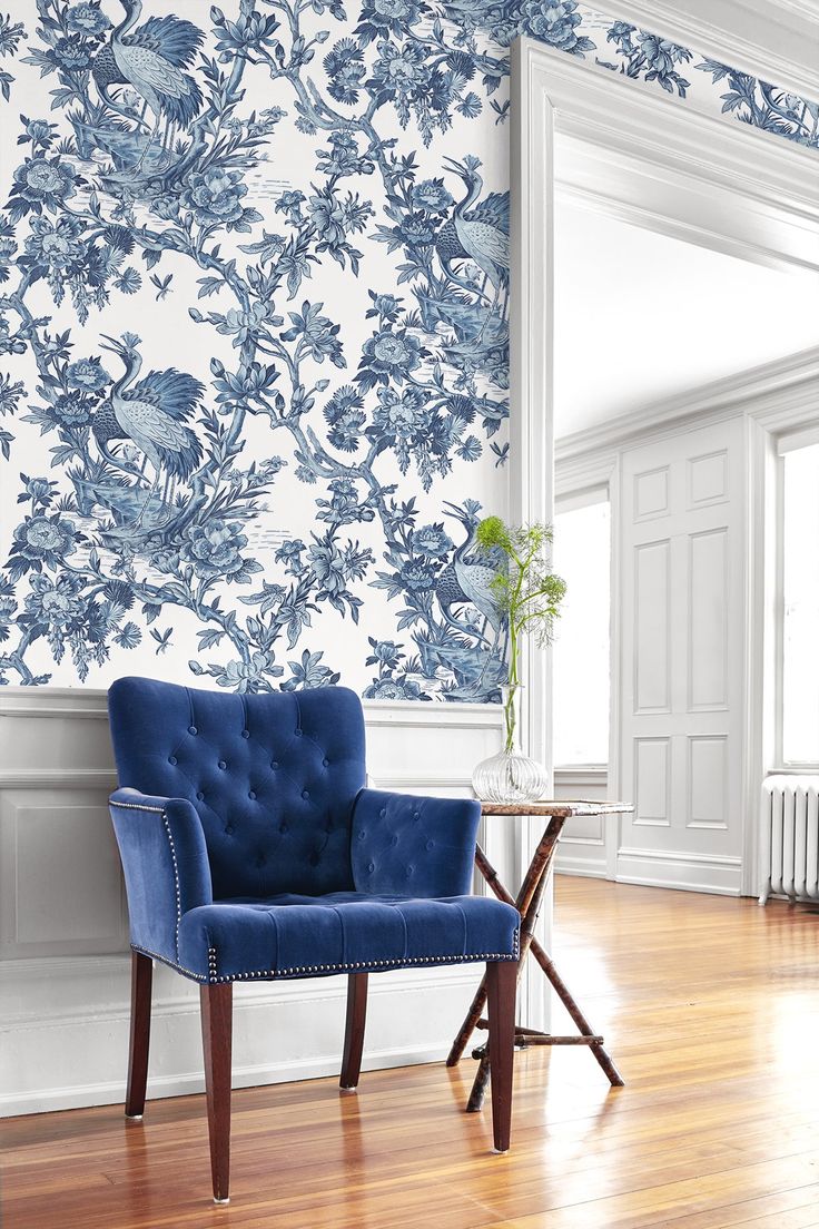 a blue chair sitting in front of a white wall