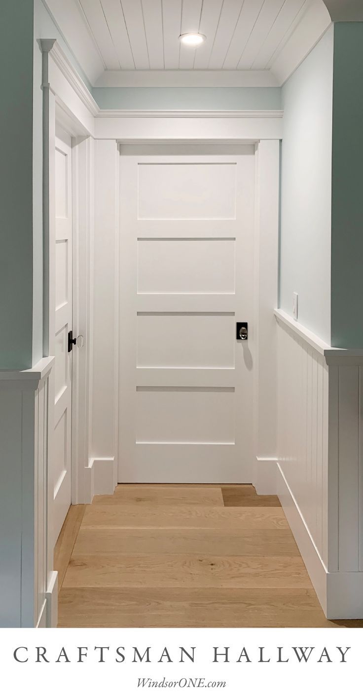 an empty hallway with white walls and wood floors