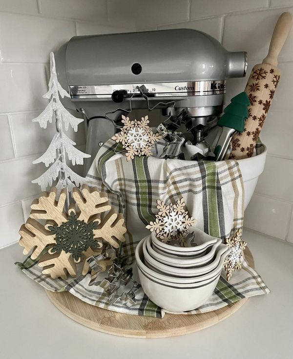 a kitchen counter topped with christmas decorations and baking utensils on top of a cutting board