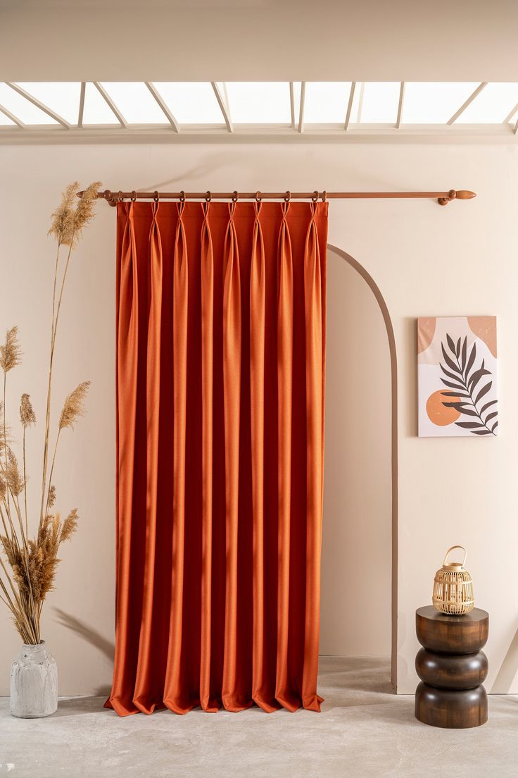 an orange curtain hanging in front of a white wall