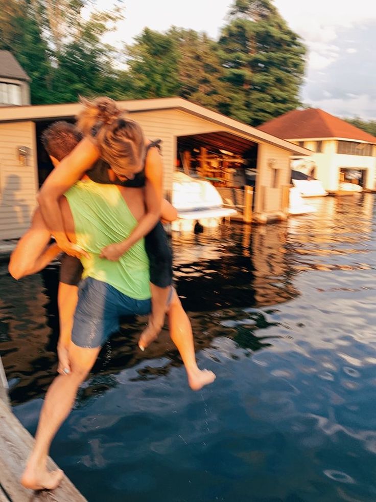 two people hugging each other while standing on a dock in the middle of flood waters