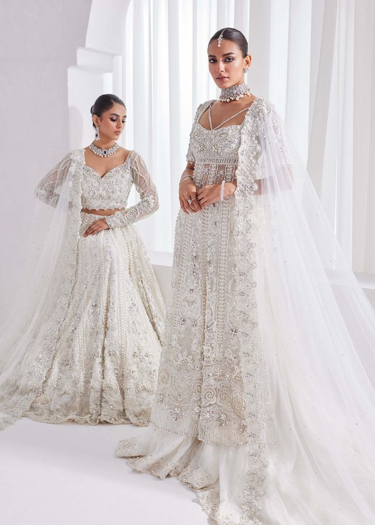 Bridal Lehenga Kameez White Pakistani Wedding Dress is an elegant attire that will give you a head-turning look on the most important day of your life. Lavish designs and perfect stitching make this Pakistani Bridal Dress a perfect choice to wear on the Nikkah day. Lehenga Kameez: The kameez in premium net fabric is intricately emblazoned with zardosi, motifs, and embroidery. This kameez in an alluring white shade is adorned with heavily embellished silverwork, naqshi, stones, sequins, and beami Elegant Semi-stitched Wedding Dress With Traditional Drape, Wedding Sets With Intricate Embroidery, Semi-stitched, Organza Wedding Set For Eid, Bollywood Wedding Sets With Dabka Work, Anarkali Dupatta With Pearl Embroidery For Weddings, Eid Ceremony Choli With Dabka Work, Semi-stitched Wedding Dresses, Traditional Wear With Pearl Embroidery For Wedding Eid, Floor-length Wedding Dress For Eid Reception