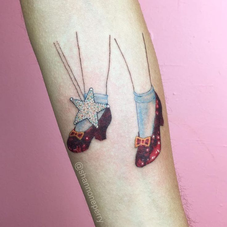 two pairs of shoes with stars on them are shown in this tattoo design, which is part of a woman's leg