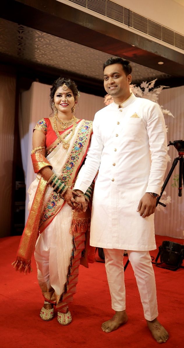 a man and woman standing next to each other in front of a red carpeted floor