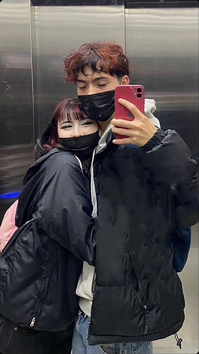 a man and woman standing next to each other in front of an escalator