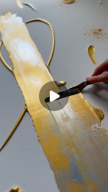 someone is painting gold paint on a piece of metal