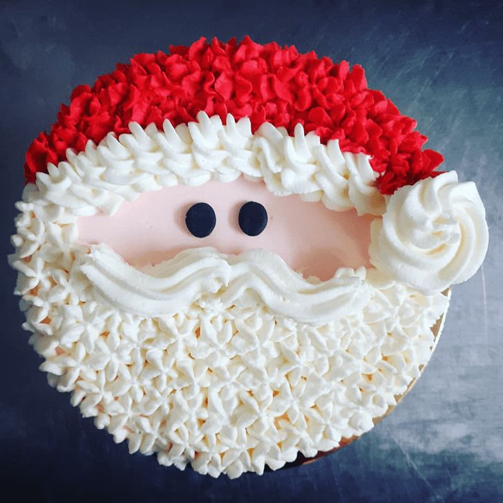 a santa clause cake with white frosting and red ruffles on the top