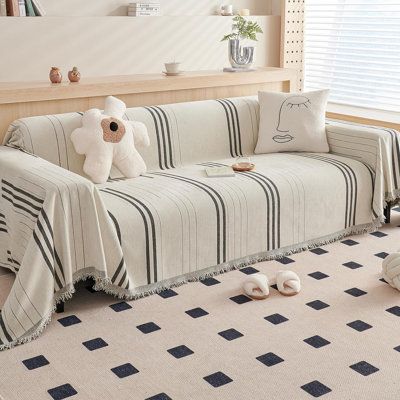 a living room filled with furniture and pillows on top of a carpeted floor next to a window