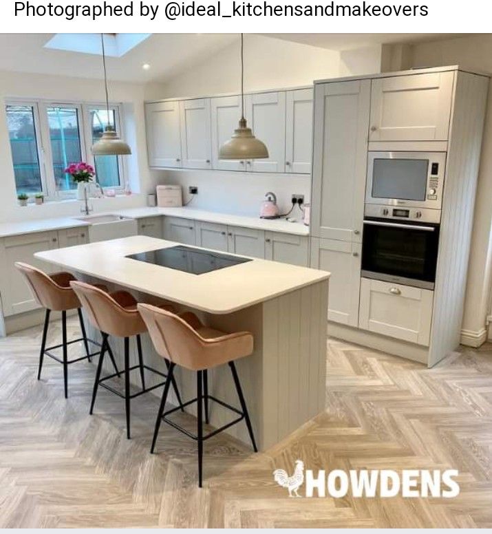 a kitchen with an island and three bar stools