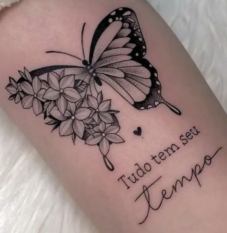 a black and white tattoo with a butterfly on it's arm that says, tudo ten su tema