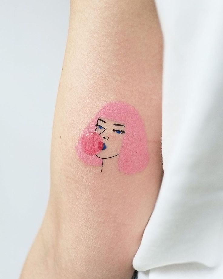 a woman's arm with a pink face on it and a heart in the middle