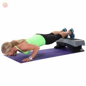 a woman is doing push ups on a purple mat