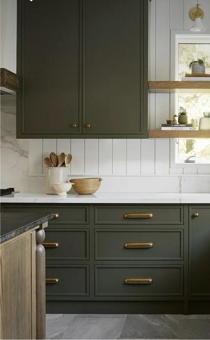 a kitchen with green cabinets and white counter tops