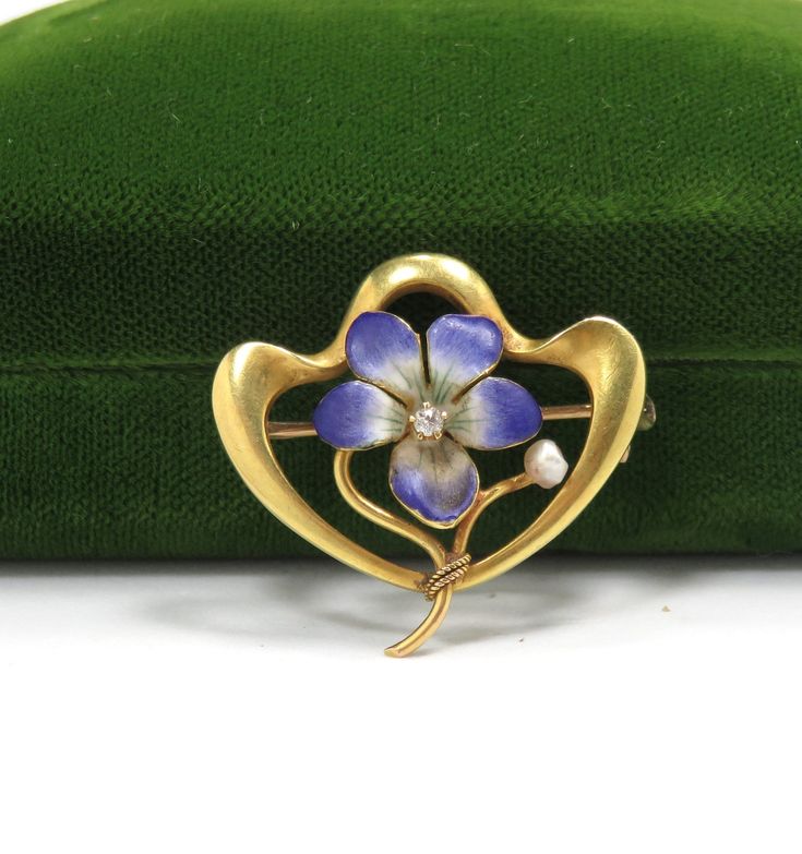 "Art Nouveau/1900 14k yellow gold hand enameling .05 carat natural diamond H in color 1\" x 1\" condition: excellent Beautiful Art Nouveau flower brooch, crafted of 14 karat yellow gold and set with hand enameling and a natural diamond.  The brooch is a nice size, measuring 1\" x 1\", and features a lavender flower delicately detailed in enamel, with a .05 carat natural diamond H in color set at the center.   The brooch is in excellent condition, with no damage to the gemstone or enamel loss.  I Yellow Gold Enamel Brooches, Yellow Gold Enamel Brooches Hallmarked, Yellow Gold Enamel Brooch Jewelry, Elegant Flower Enamel Pin Collectible, Gold Enamel Art Nouveau Jewelry, Elegant Yellow Gold Enamel Brooches, Elegant Yellow Gold Enamel Pin Gift, Hallmarked Enamel Brooches As Gifts, Hallmarked Enamel Brooches For Gifts