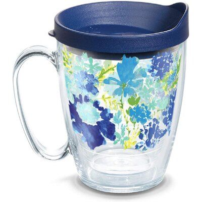 a glass cup with purple lid and blue flowers on it