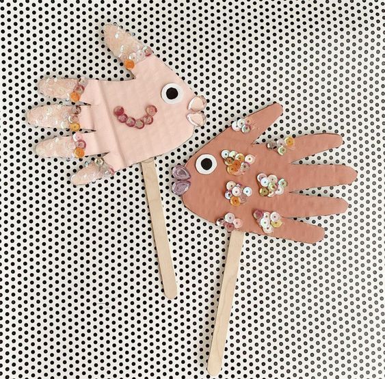 two hand puppets made out of paper on top of a polka dot tablecloth background