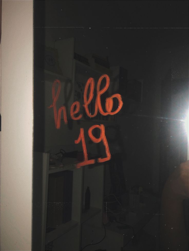 the reflection of a person standing in front of a mirror with writing on it that reads hello 19