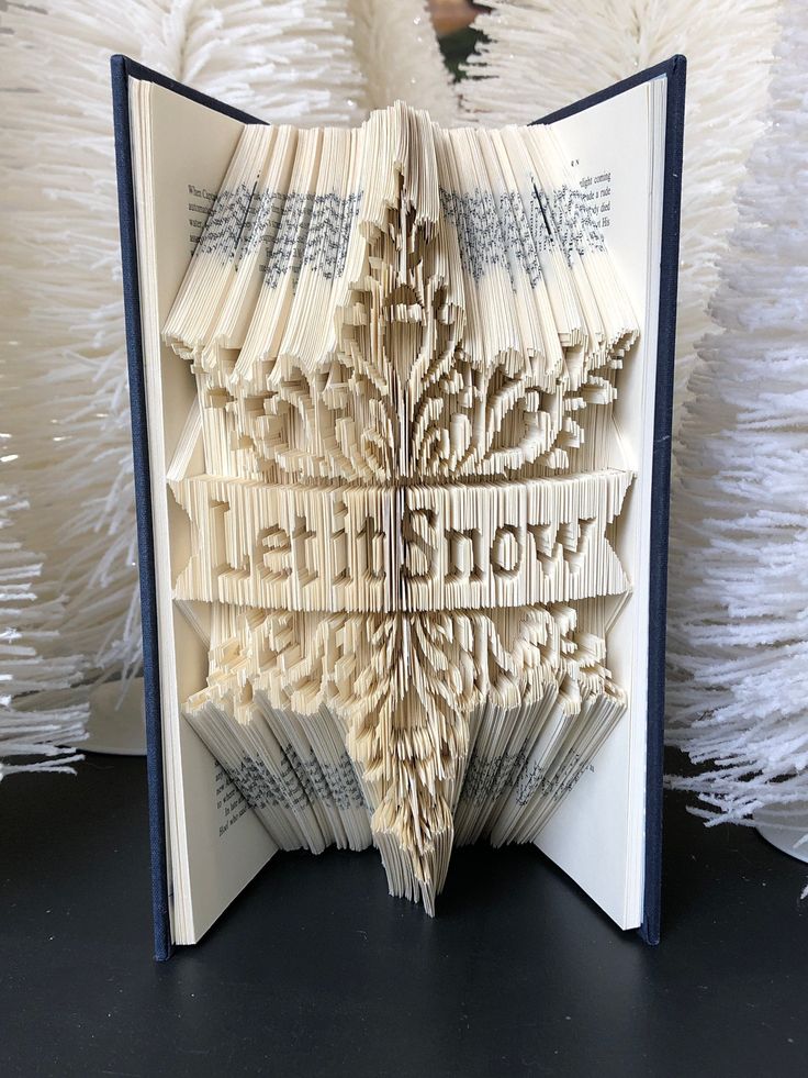 an open book that has been folded into the shape of a snowflake