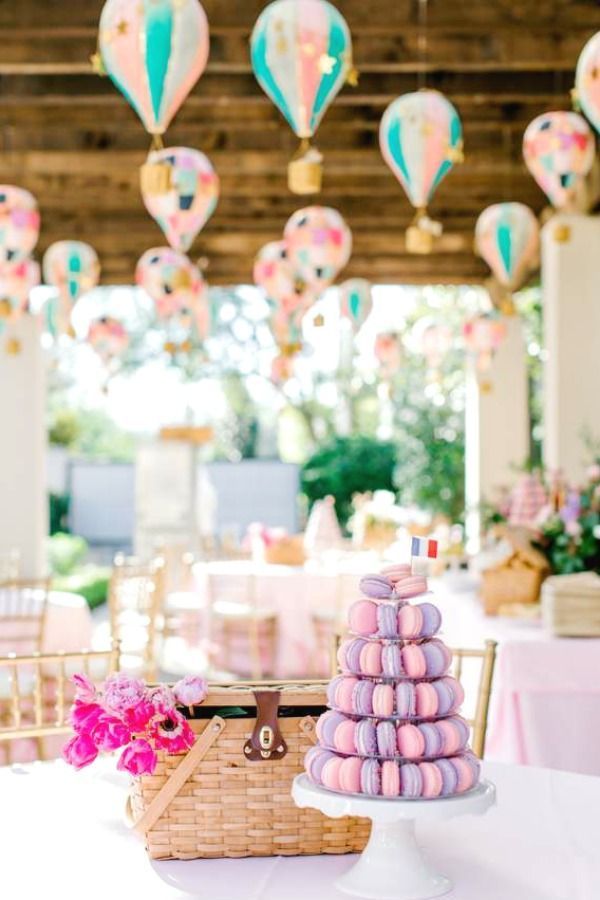 a table topped with pink macaroons and hot air balloons