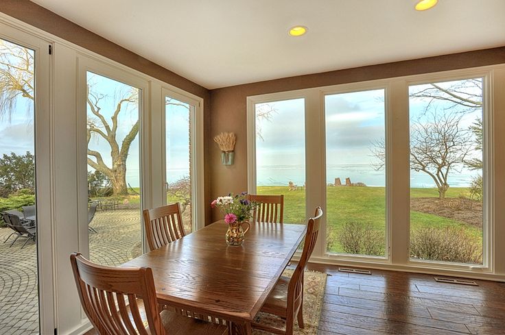 an empty dining room with large windows overlooking the ocean