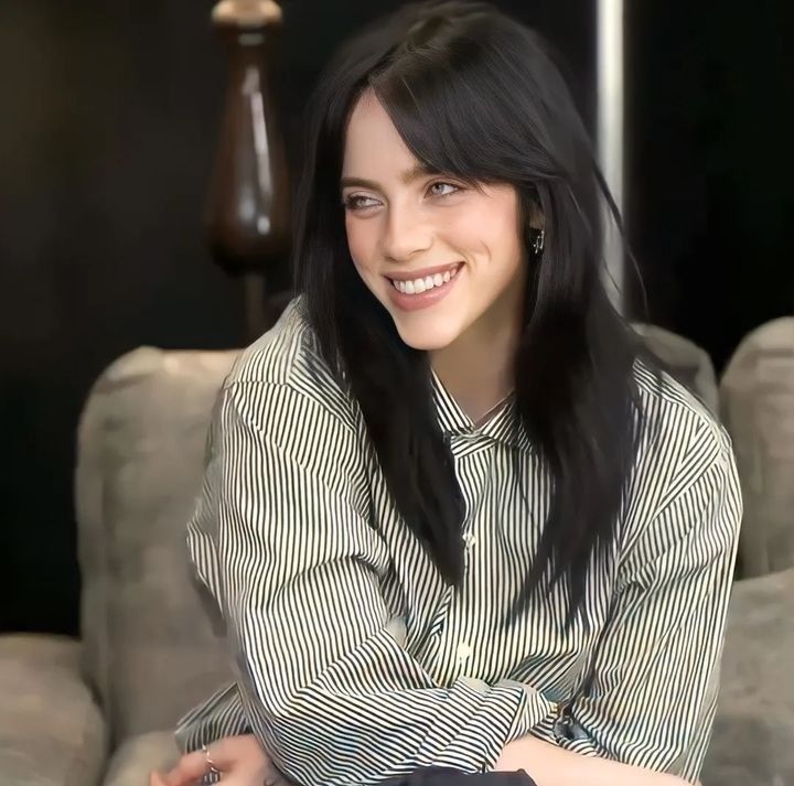 a woman sitting on a couch smiling at the camera