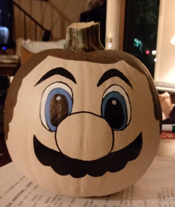 a pumpkin with a face painted on it sitting on top of a piece of paper