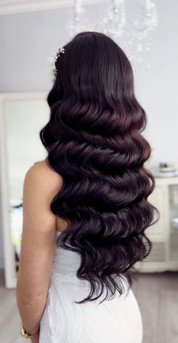 the back of a woman's head with long, wavy hair in front of her