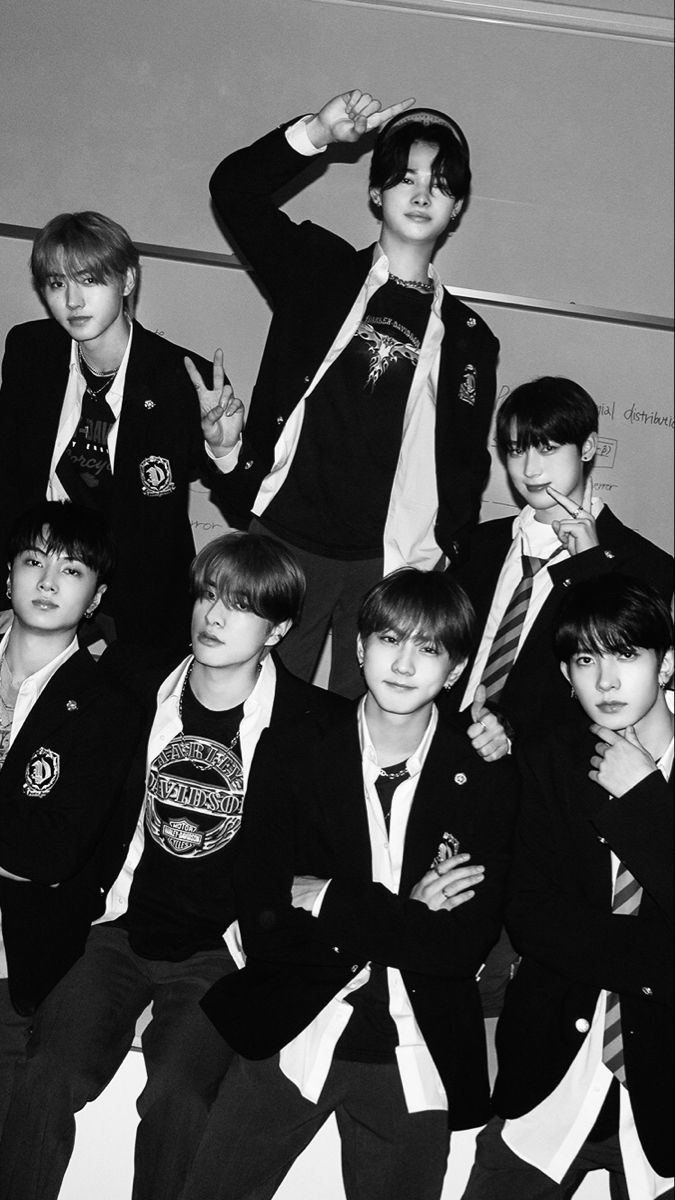 black and white photo of boys in school uniforms posing for the camera with one hand on his head