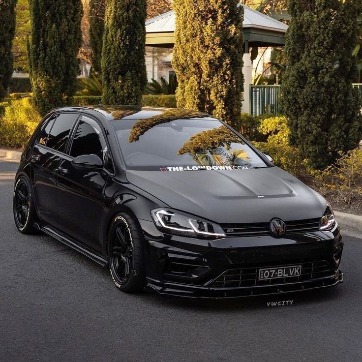 the volkswagen golf gtr is parked in front of some trees