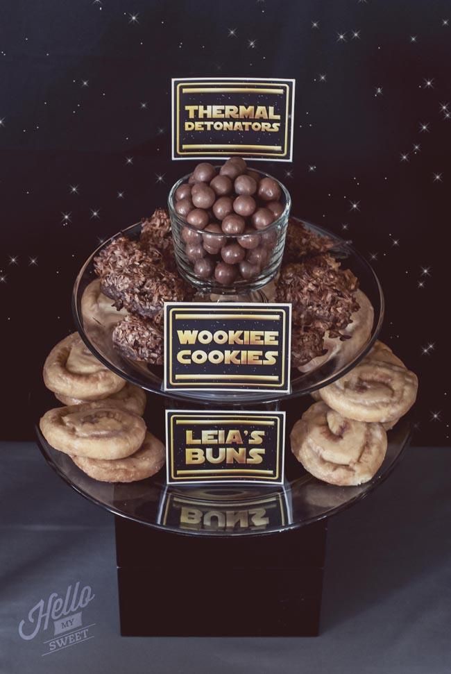 there are some cookies and donuts on the table with labels in front of them