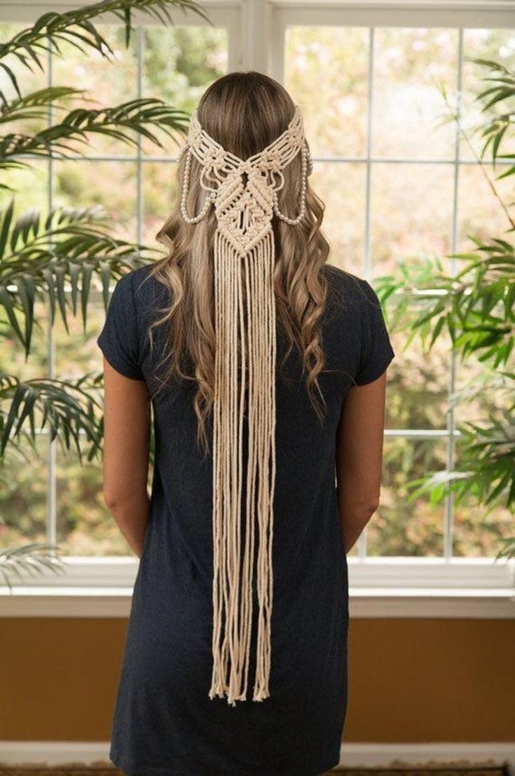 a woman standing in front of a window wearing a white macrame headdress