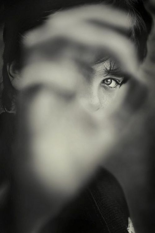 black and white photograph of a woman's face with her hands in the air